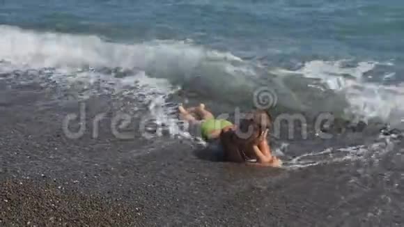 冲浪的男孩子覆盖波那个男孩躺在岩石上的海里水使婴儿窒息视频的预览图