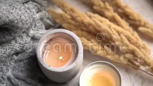 舒适燃烧的蜡烛和灰色针织毛毯在真正的室内冬季家庭装饰视频的预览图