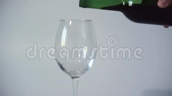 葡萄酒从瓶子里倒入透明的空玻璃中特写视频的预览图