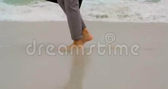 在海滩上商务人员赤脚行走带着公文包视频的预览图