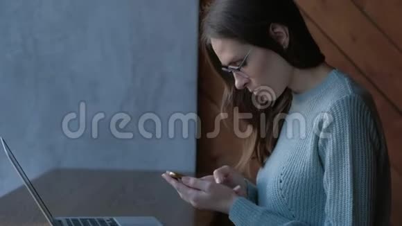 女性在咖啡店使用智能手机和笔记本电脑视频的预览图