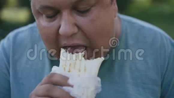 一个吃有害和美味的肖玛的胖子的特写视频的预览图
