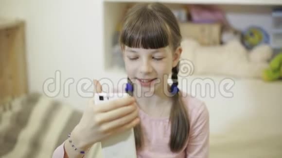 小女孩用智能手机和她的朋友视频聊天视频的预览图