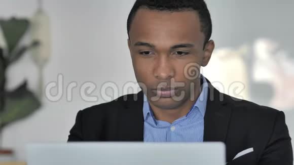 在笔记本电脑上工作时头痛的美国黑人休闲商人视频的预览图