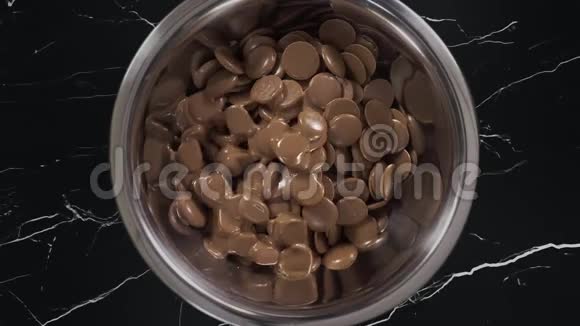 巧克力滴在铁碗里实时融化由巧克力制成的甜点和糖果经过精心制作的巧克力视频的预览图