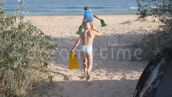 带着面具的孩子去海边穿着充气背心在海滩上的男孩在潜水用脚蹼的孩子手里视频的预览图