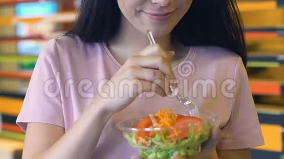 微笑的女孩在拍照前享受新鲜蔬菜沙拉健康饮食视频的预览图