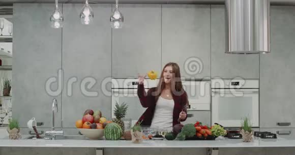 在现代化和美丽的厨房里有一个大厨房岛一位漂亮的年轻女士在做食物和玩耍时跳舞视频的预览图