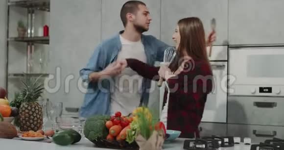 在一个现代厨房的年轻人和他的女朋友在做食物时浪漫他们是非常有魅力的视频的预览图