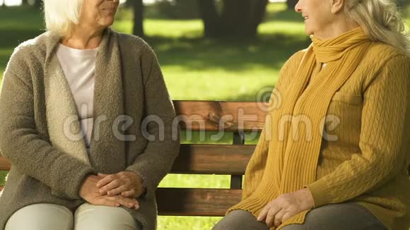 坐在长凳上的老女人谈论最新消息谈论邻居视频的预览图