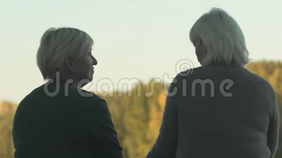 老妇人在外面和朋友聊天一起在公园休息交流视频的预览图