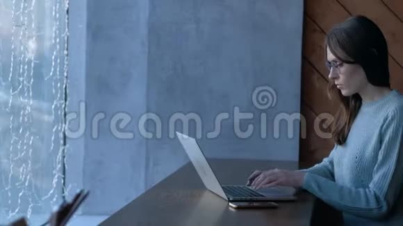 年轻女孩自由职业者在咖啡馆里做笔记本电脑视频的预览图