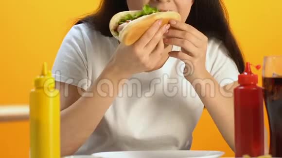 饥饿的女性咬着美味的热狗享受美味的快餐特写视频的预览图