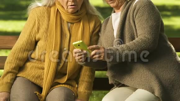 两个使用智能手机的老女人对现代技术感到惊讶学习应用程序视频的预览图