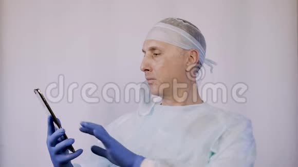 医生在平板电脑上看病人的x光片他正在准备手术视频的预览图