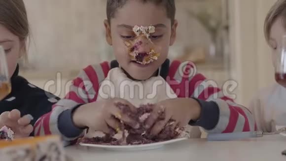 一个非裔美国男孩在蛋糕上弄脏了一幅肖像在桌子上的盘子里捏了一块蛋糕二视频的预览图
