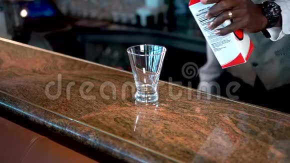 酒保把草莓糖浆倒入柜台上的杯子里熔岩流鸡尾酒视频的预览图