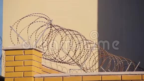 被夕阳照射的砖围栏上的铁丝网视频的预览图