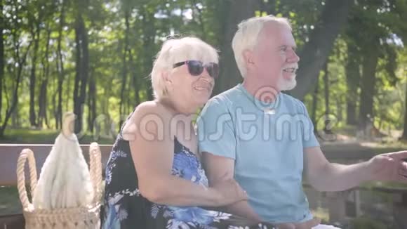 幸福的成熟夫妇坐在长凳上欣赏大自然年长的男人和女人一起放松户外休闲视频的预览图