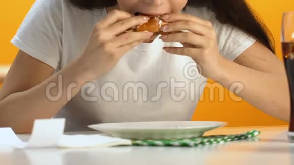 饥肠辘辘的女人吃汉堡时胃口大开快餐成瘾者体重增加视频的预览图