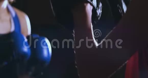 中等镜头的美丽健身女子拳击手treneruemsya打击速度聚焦手套与教练在拳击俱乐部慢慢视频的预览图