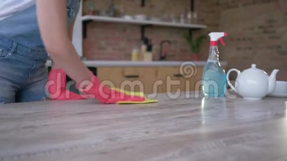 清洁服务妇女戴手套在厨房用抹布和洗涤剂洗桌子视频的预览图