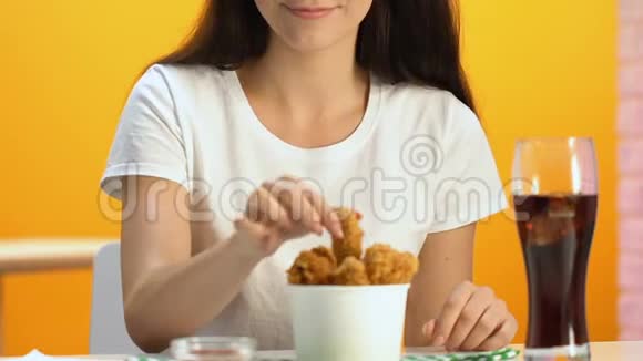 快乐的女性在快餐店享用脆炸鸡和苏打水视频的预览图