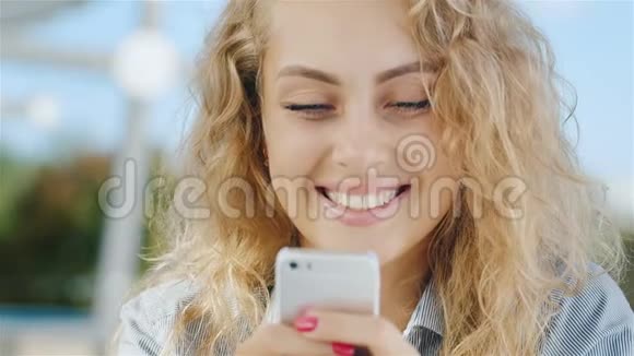 一位迷人的年轻女子看手机屏幕的肖像微笑视频的预览图