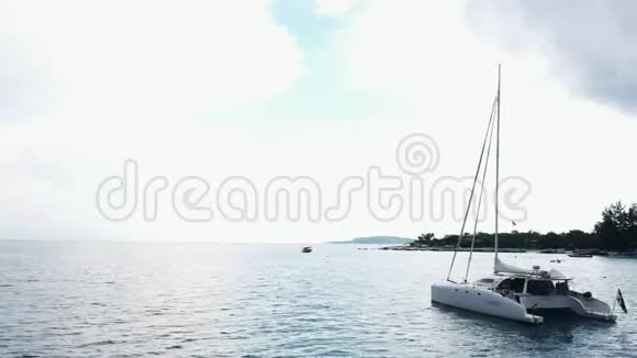 空中观赏一艘停泊的双体帆船人们可以在甲板上日光浴视频的预览图