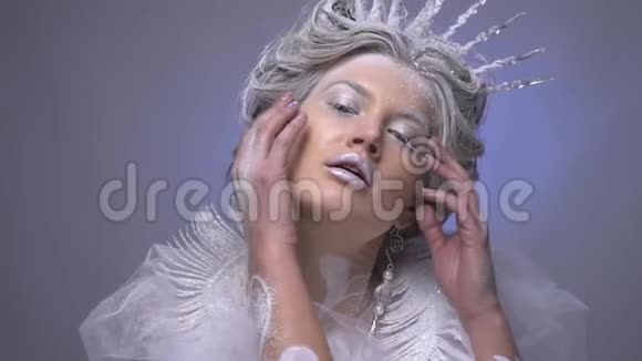 美丽的雪皇后在工作室摆姿势抚摸她的脸视频的预览图