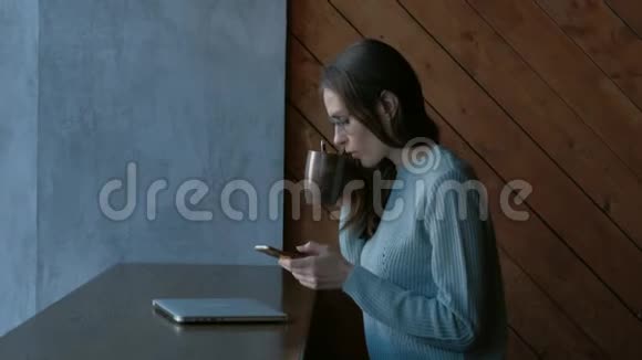女性在咖啡店使用智能手机和笔记本电脑视频的预览图