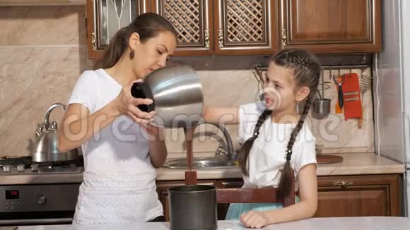妈妈和女儿在家的厨房里一起做海绵蛋糕视频的预览图