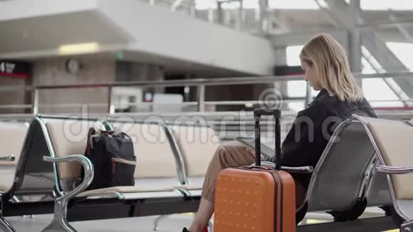 在机场有数字设备的女人视频的预览图
