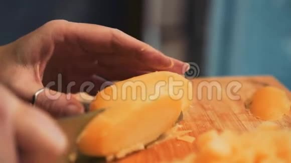 那个女孩用刀子把土豆切在切割板上不错的特写回放缓慢视频的预览图