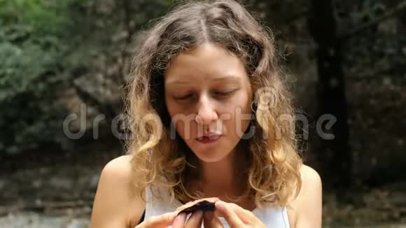 幸福的女人吃无花果的肖像闭着眼睛享受大自然的味道视频的预览图
