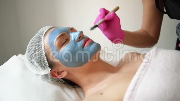 去脸面膜水疗美容治疗护肤女人在水疗沙龙接受美容师的面部护理女人做女人视频的预览图