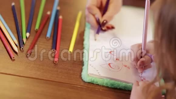 母亲和女孩的双手用彩色铅笔画画视频的预览图