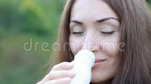 女人喝乳制品牛奶凯菲酸奶乳制品店的女孩脸和白胡子特写视频的预览图