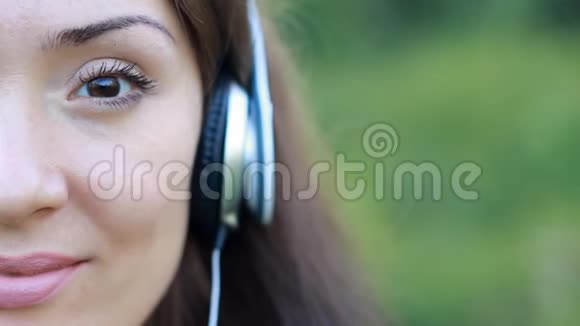 戴着耳机听音乐的漂亮女人半张脸特写心情愉悦放松放松视频的预览图