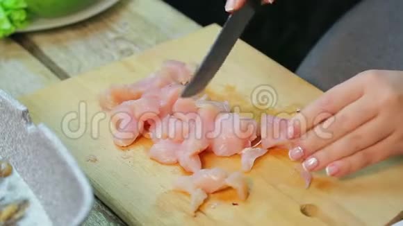 女人用刀子把鸡肉切成薄片视频的预览图