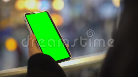 女人拿着预先准备好的手机站在购物中心做广告视频的预览图