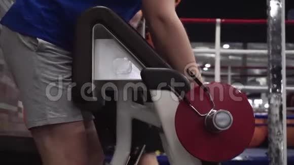 漂亮的年轻人在健身房的机器上做二头肌卷发努力工作视频的预览图