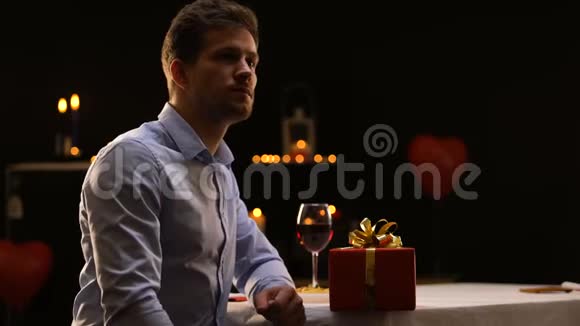 穿着衣服的年轻人吹蜡烛把礼物留在桌上走开了视频的预览图