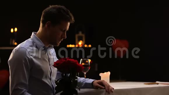 焦虑的男性吹灭蜡烛留下一束玫瑰不成功的约会视频的预览图
