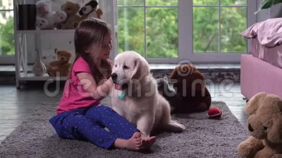 小孩在家里坐在地毯上玩小狗视频的预览图