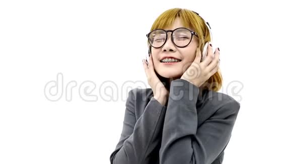 关闭亚洲女商人听白色耳机音乐的现场视频视频的预览图