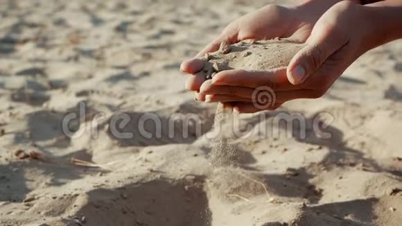 下面的动作结束沙子穿过一个年轻女人的手指沙子穿过了一个视频的预览图