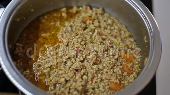 用新鲜胡萝卜和橄榄油在砂锅中煮碎的肉视频的预览图