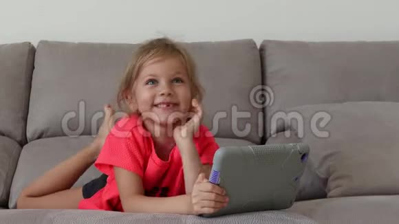 快乐的女孩在家玩平板电脑有趣可爱的孩子在房间里玩得很开心视频的预览图