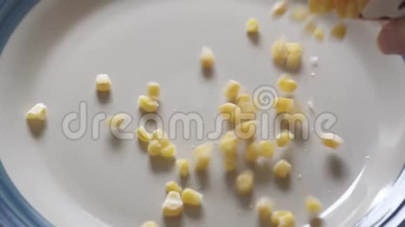 在盘子上从袋子里倒入冷冻甜玉米视频的预览图